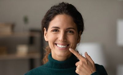 a woman pointing at her healthy gum line