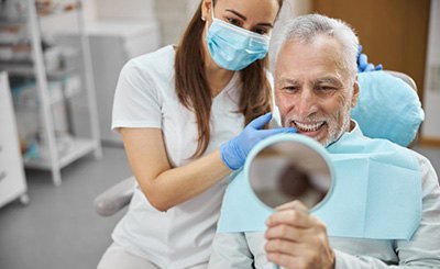 a patient checking his teeth with a mirror