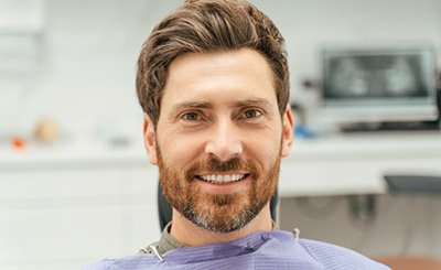 Dental patient signing paperwork on clipboard