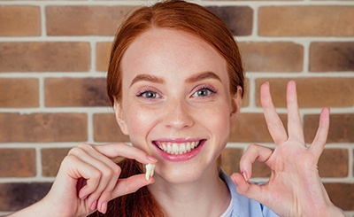  A woman holding her wisdom tooth